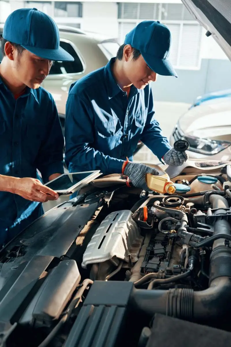 Two mechanics changing engine oil at Alan Aston Motor Engineers Evesham