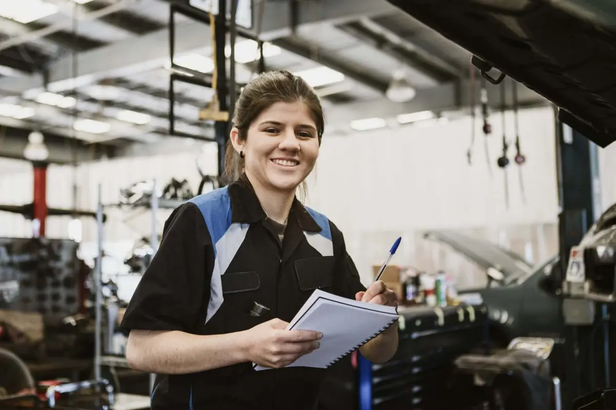 Smiling mechanic with a clipboard in the workshop at Alan Aston Motor Engineers Evesham
